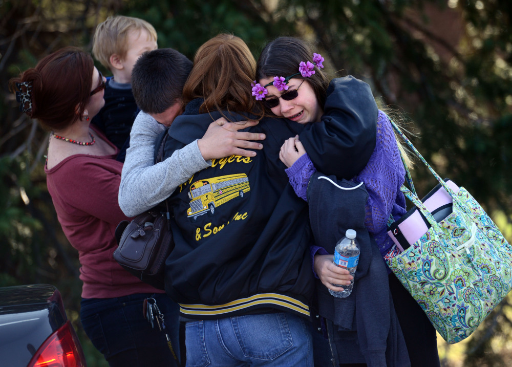 Parents and students embrace near Franklin Regional High School after 21 students and a security guard were injured in an attack by a knife wielding suspect Wednesday in Murrysville, Pa., near Pittsburgh.