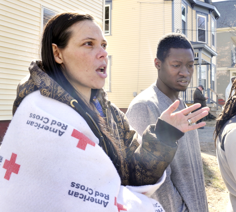 Crystal Thompson describes how she and her boyfriend, Johnny Green (right) were able to escape a building fire on Howe Street in Lewiston that left several dozen people homeless.