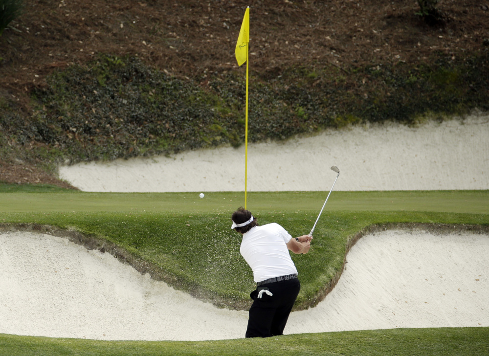 Phil Mickelson hits out of a bunker on the 12th hole during the second round of the Masters golf tournament Friday, April 11, 2014, in Augusta, Ga.