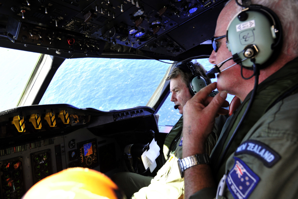 Royal New Zealand Air Force co-pilot squadron leader Brett McKenzie, left, and flight engineer Trent Wyatt sit in the cockpit aboard a P-3 Orion looking for the missing Malaysia Airlines Flight MH370 on Friday.