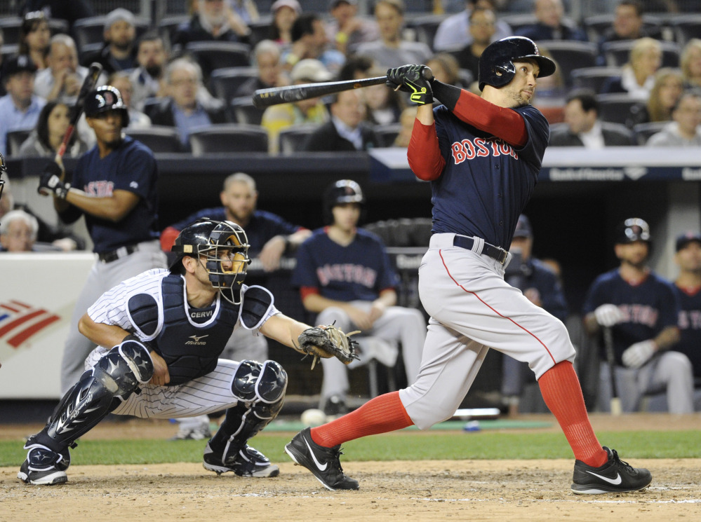 Boston Red Sox batter Grady Sizemore hits a three-run home run as New York Yankees catcher Francisco Cervelli, left, looks on during the sixth inning of a baseball game Friday, April 11, 2014, at Yankee Stadium in New York.