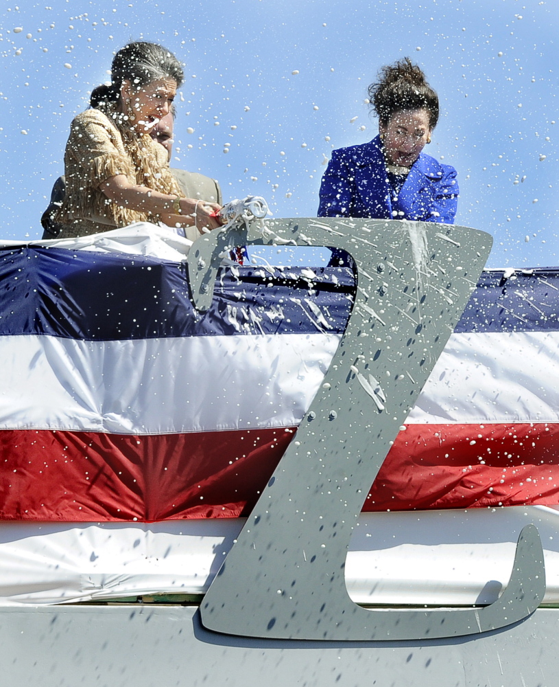 Admiral Elmo Zumwalt’s daughters, Ann Zumwalt and Mouzetta Zumwalt-Weathers, break champagne bottles on a large letter Z during the christening of the USS Zumwalt at Bath Iron Works. Thousands witnessed Saturday’s event celebrating the shipyard, the new warship and the memory of its namesake.