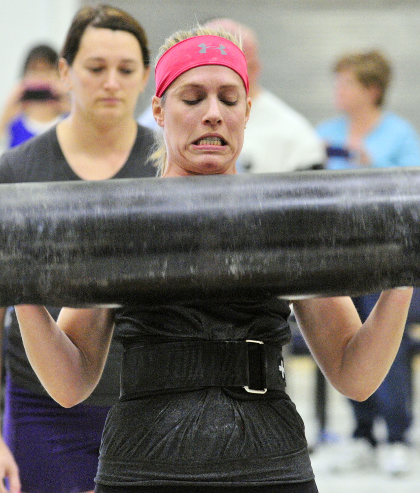 Up Lifting: Annie Philbrick grimaces as she sets down the log after making a lift in the women’s novice division of max log clean during the Central Maine Strongman 7 competition on Saturday at Augusta Armory. Increasingly heavier weights are added to the metal log each round until only one last competitor can the lift it.