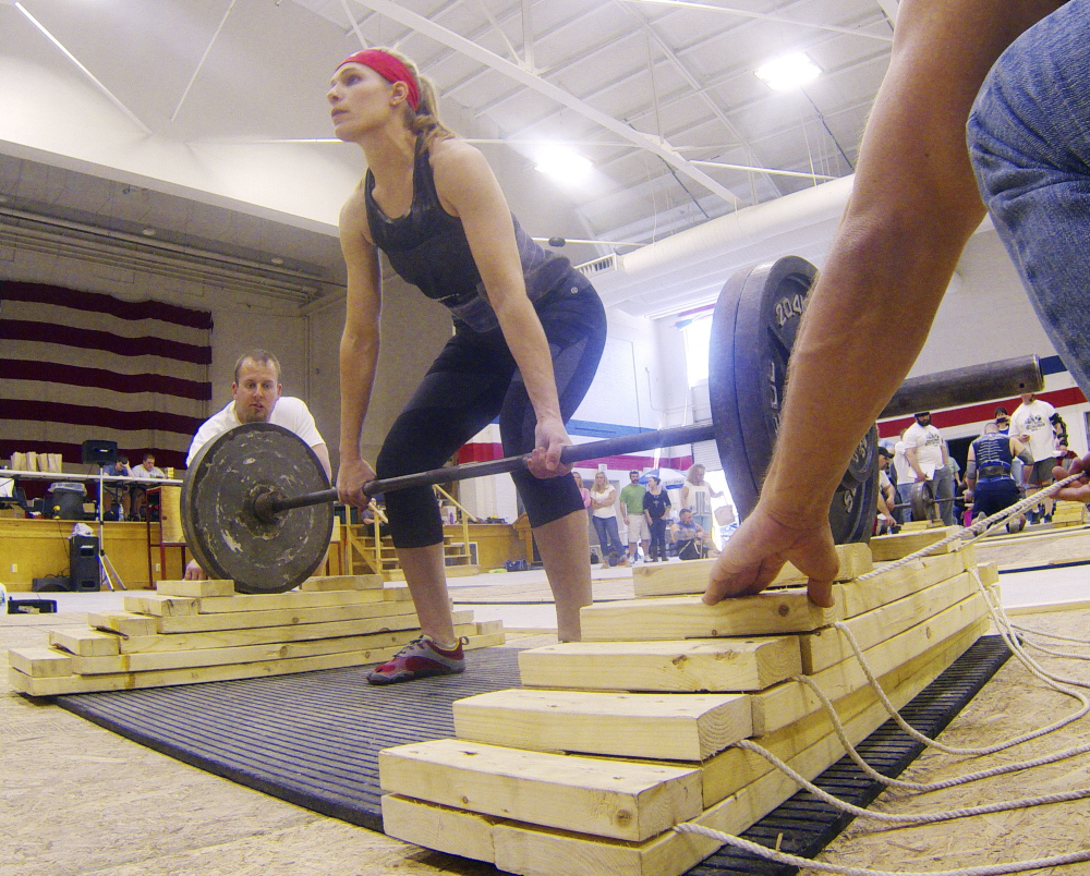Strong Woman: Annie Philbrick, of Sidney, gets into position the women’s novice division of descending dead lift during the Central Maine Strongman 7 competition on Saturday at Augusta Armory. Competitors have a minute to deadlift the weight as many reps as possible. A wooden support is pulled out with each lift, after they’re all gone competitors keep lifting off the floor.