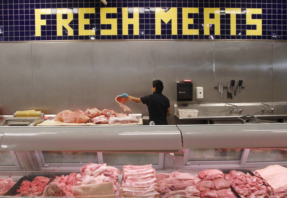 In this July 25, 2012 file photo butcher Freddie Quina cuts meat at Super Cao Nguyen in Oklahoma City.