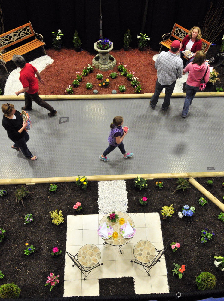 Sign of spring: People walk past displays during the Manchester Lions Home and Garden Show on Saturday at the Augusta Civic Center.