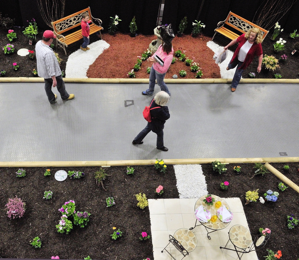 Sign of spring: People walk past displays during the Manchester Lions Home and Garden Show on Saturday at the Augusta Civic Center.