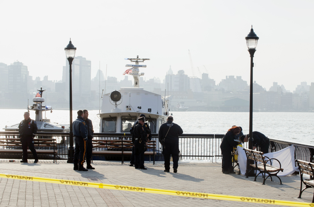 Police investigate the scene Sunday after divers found the bodies of two men in the Hudson River near Sinatra Park in Hoboken, N.J. Police have not identified the victims.