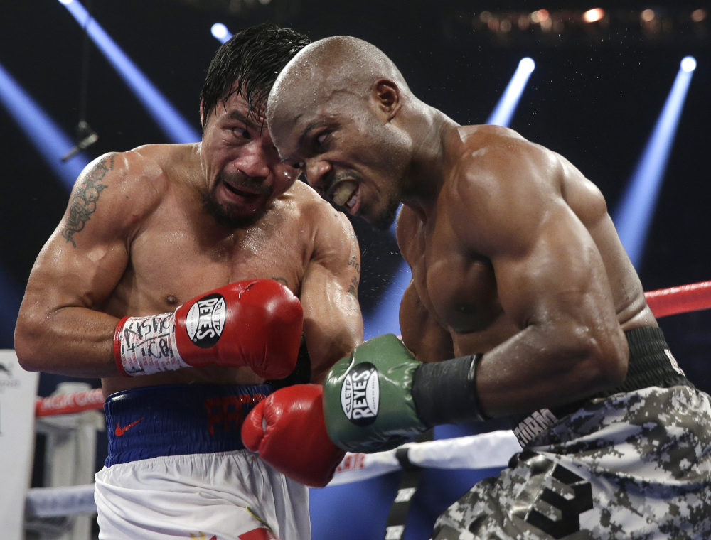 BACK ON TOP: Manny Pacquiao, left, trades blows with Timothy Bradley on Saturday in their WBO welterweight title fight in Las Vegas. Pacquiao won the bout by unanimous decision.