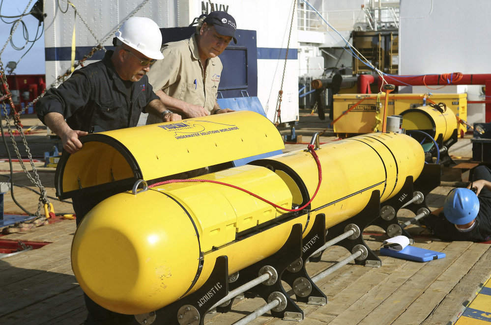 Australian Defense Force Phoenix International’s Chris Minor, left, and Curt Newport inspect an autonomous underwater vehicle before it is deployed from ADV Ocean Shield in the search of the missing Malaysia Airlines Flight 370 in the southern Indian Ocean.