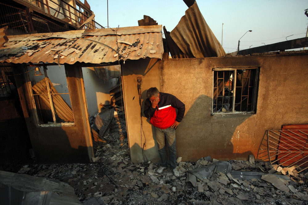 A man cries next to the remains of his house after a forest fire destroyed it in Valparaiso, Chile, Sunday.