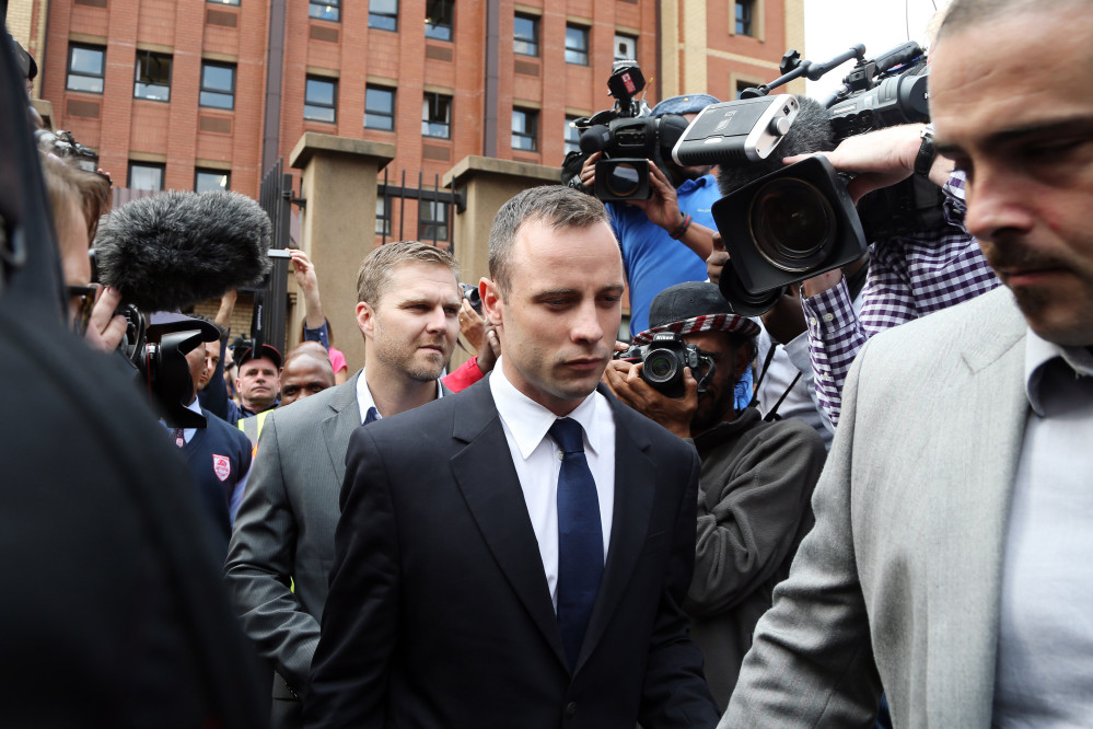 Oscar Pistorius, center, leaves the high court in Pretoria, South Africa, Tuesday. He is charged with murder for the shooting death of his girlfriend, Reeva Steenkamp, on Valentines Day in 2013.