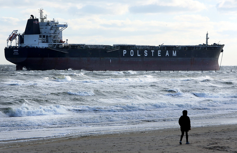 A person walks along the beach Wednesday near where the 751-foot bulk carrier Ornak ran aground Tuesday night in the lower Chesapeake Bay near First Landing State Park, in Virginia Beach, Va. There were no reports of injuries, damage or pollution from the grounding, and the vessel was not blocking other water traffic, said Coast Guard spokesman Petty Officer First Class Brandyn Hill.