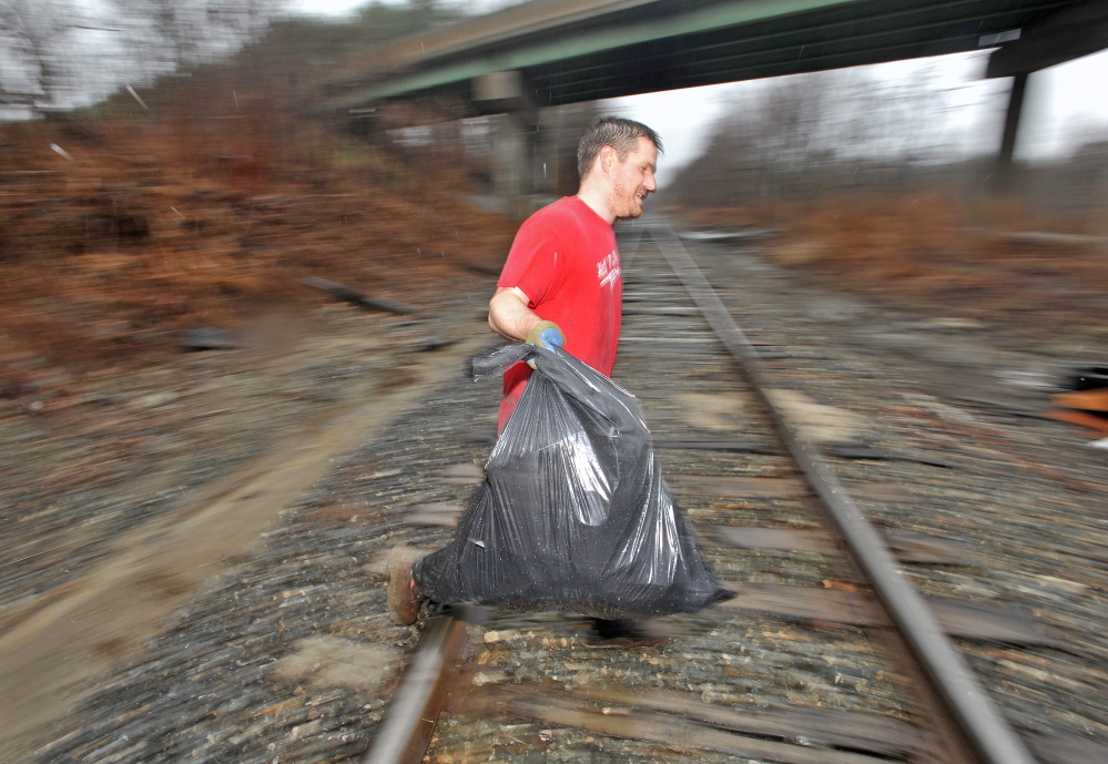 CLEANING UP: Ward 4 Waterville City Councilor Erik Thomas cleans up trash under the County Road overpass Tuesday. Thomas, chairman of the city’s solid waste committee, took the initiative to clean up illegally dumped trash. “We need less complainers and more doers,” Thomas said. “If you see something that needs to be done, do it.”