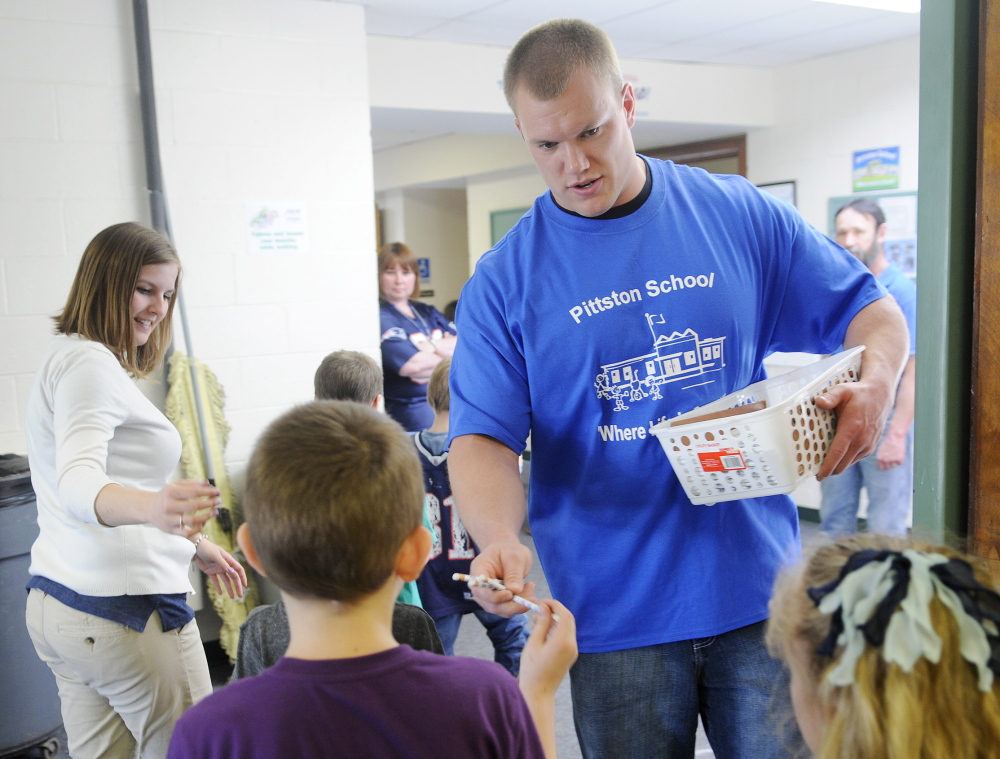 MAKING A POINT: National Football League player Matt Mulligan hands Pittston Consolidated School students pencils Wednesday. His visit was a reward for the school’s participation in Fuel Up to Play 60, the NFL’s nutrition and fitness initiative.