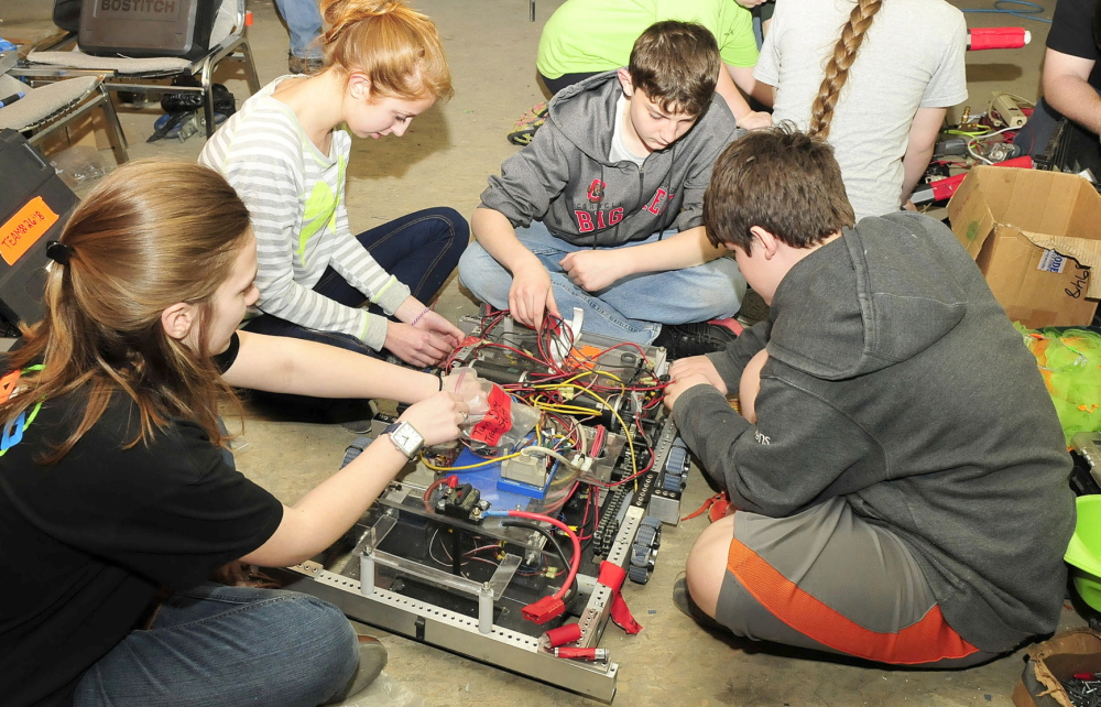 ROBOTIC SURGERY: Messalonskee High School robotic team members reassemble parts of the twin hard drive of their robot at donated space in the Wrabacon company in Oakland. Their entry will compete in the national championship competition in St. Louis, Mo. From left are Taylor Ferguson, Marina Barnes-Berniger, Vann Guarnieri and Michael Viens.