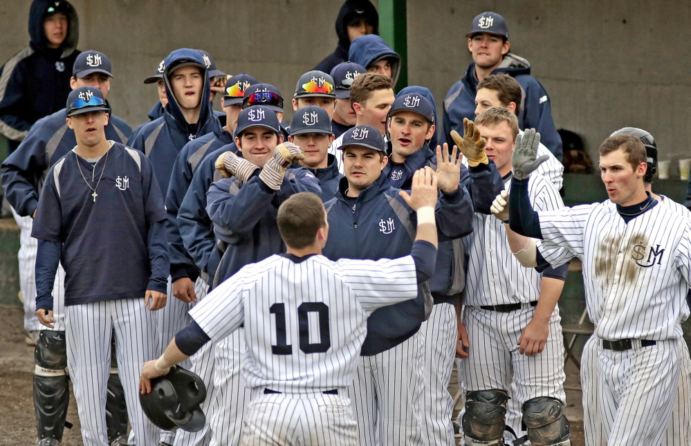 Troy Thibodeau of USM is greeted by his teammates Friday after hitting a solo home run in the fourth inning of the 5-3 victory against Bowdoin at Gorham. The Huskies, who are ranked sixth in the country in Division III, shut down the Polar Bears down the stretch with strong relief pitching.