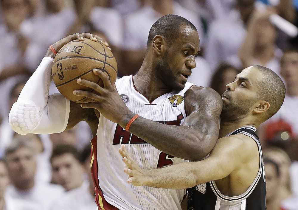 BACK IN THE PLAYOFF GRIND: San Antonio Spurs point guard Tony Parker, right, and Miami Heat small forward LeBron James collide during the second half of Game 6 of the NBA Finals last year in Miami. A rematch of last year’s thrilling NBA Finals finish is possible, but the Spurs and Heat would have to get through tough paths to get there.