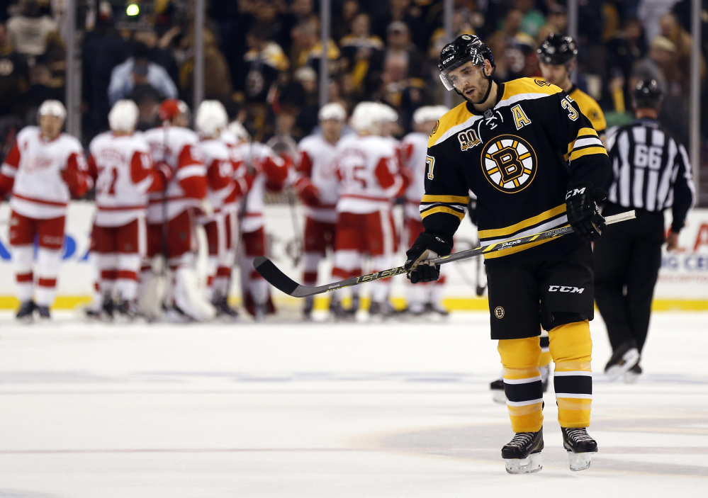 Boston Bruins’ Patrice Bergeron skates off the ice as the Detroit Red Wings celebrate their 1-0 win in Game 1 of a first-round NHL playoff hockey series, in Boston on Friday, April 18, 2014.