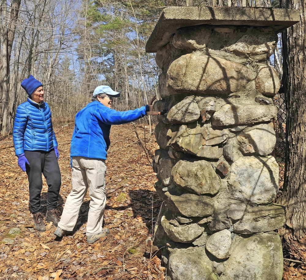 Relic of a bygone era: Sue Bell, left, and city councilor Dale McCormick look at a stone gatepost on an old carriage road leading into the former Ganneston Park during a walking tour of Howard Hill on Friday in Augusta. The wooded hill is the backdrop to the State House.