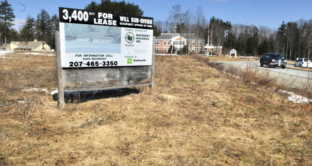 TENANTS WANTED: A sign advertising retail space stands at FirstPark in Oakland in a field beside current tenants Kennebec Veterinary Services, left, and PFBF Co.
