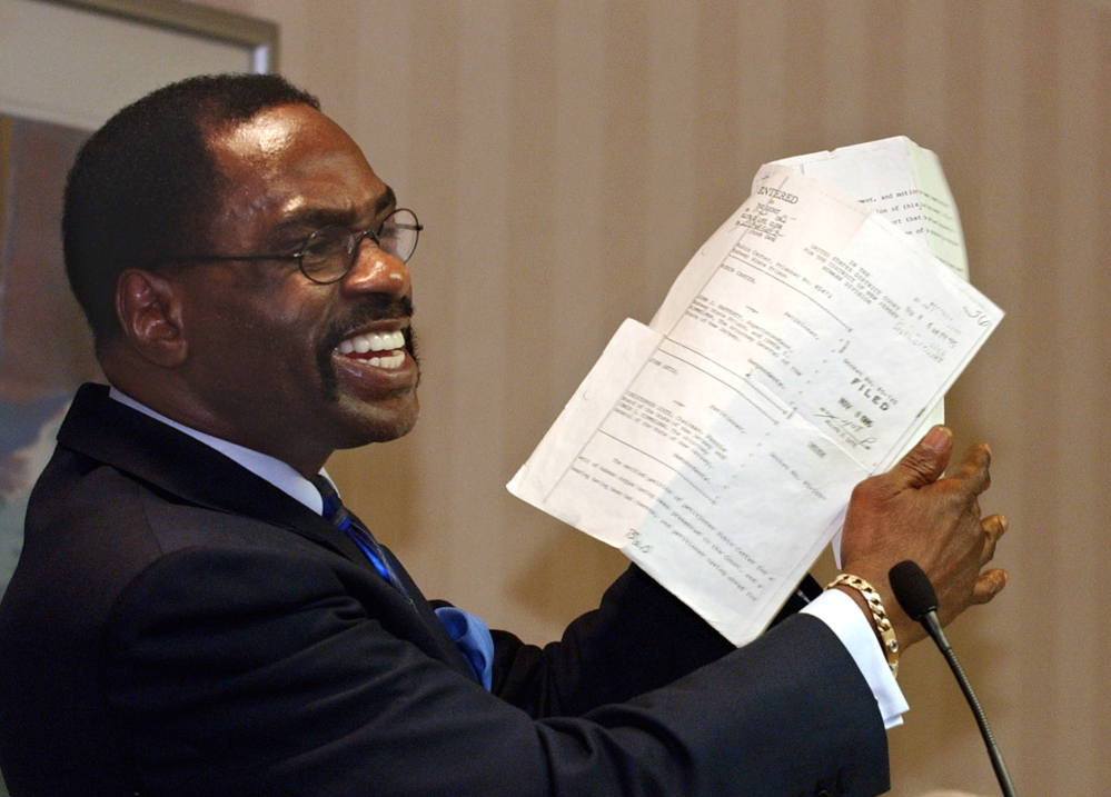 Former boxer Rubin, “Hurricane” Carter, holds up the writ of habeas corpus that freed him from prison, during a news conference held in Sacramento, Calif., in January 2004. Carter, who spent almost 20 years in jail after twice being convicted of a triple murder he denied committing, died at his home in Toronto on Sunday. He was 76.