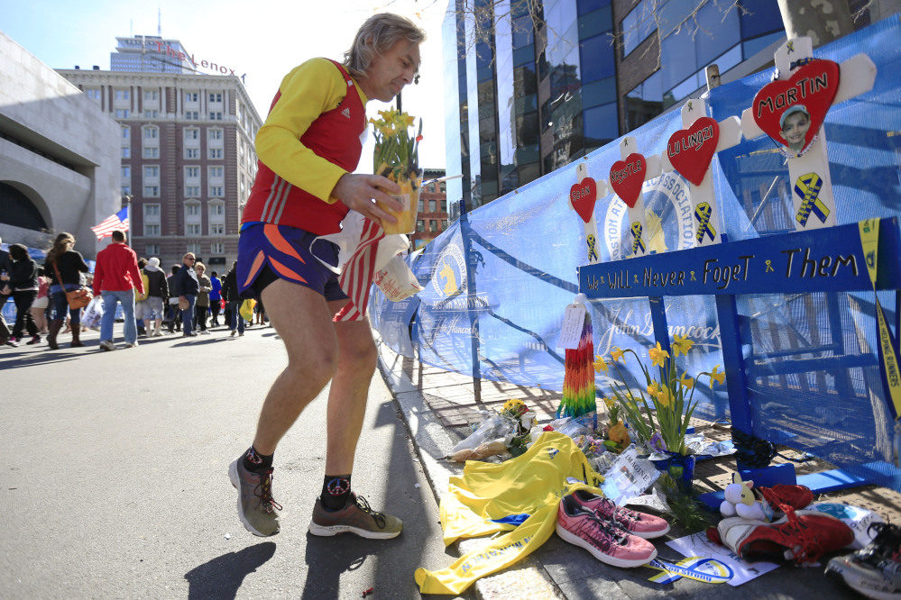 Memorial Runners: Ron McCracken, of Dallas, pays his respects at a makeshift memorial honoring to the victims of the 2013 Boston Marathon bombings ahead of Monday’s 118th Boston Marathon, Sunday, in Boston. McCracken’s race last year was cut short due to bombings and Monday’s race will mark his 14th year running in the Boston Marathon. The memorial is where the first of two explosions happened last year near the finish line.