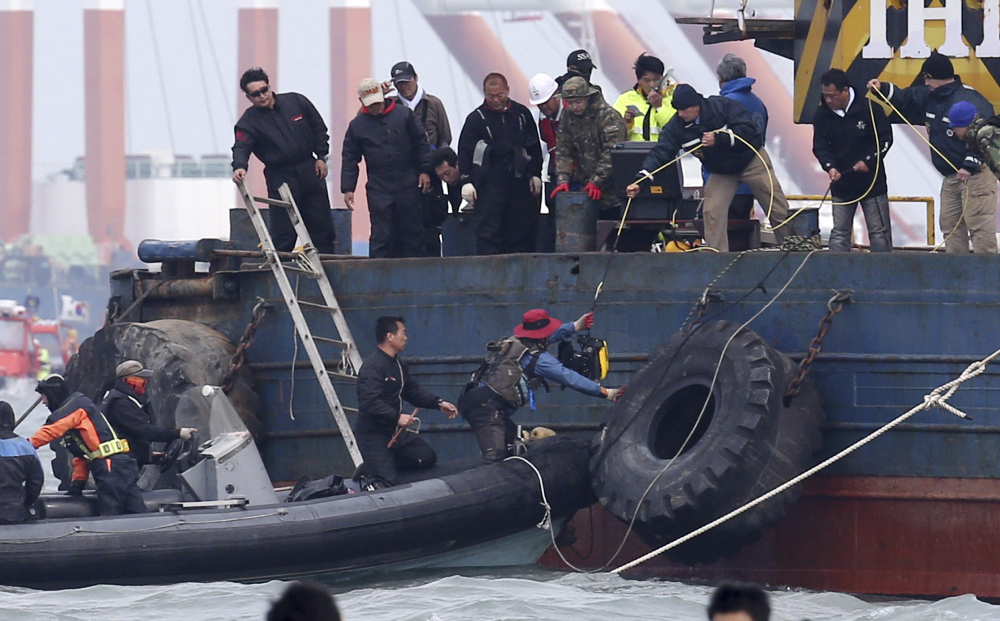 U.S. technicians hand off a remotely-operated vehicle to South Korean rescue team members to be used for searching for passengers of the sunken ferry Sewol in the water off the southern coast near Jindo, South Korea, on Monday.