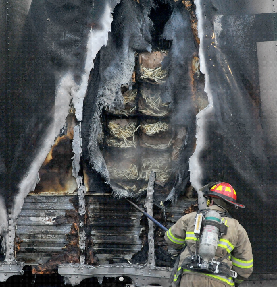 Hot brakes: Firefighters from the Waterville Fire Department extinguish a fire in a truck’s trailer full of french fries in the Walmart parking lot in Waterville Tuesday evening.