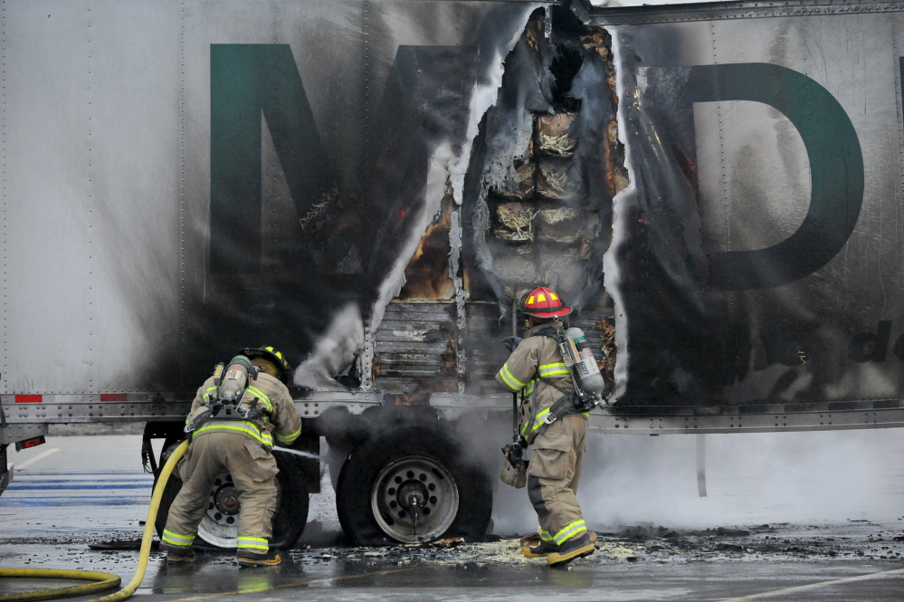 Hot brakes: Firefighters from the Waterville Fire Department extinguish a fire in a truck’s trailer full of french fries in the Walmart parking lot in Waterville Tuesday evening.