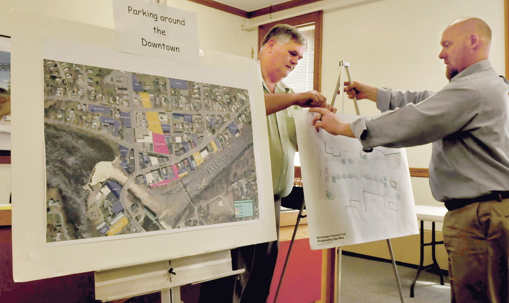 BIG PLANS: Skowhegan Director of Economic and Community Development Jeff Hewitt, left, and engineer Jim Lord hang drawings of the town municipal parking lot and plans for the three-phase improvement project on Tuesday. Planned improvements include sidewalks, curbing, green spaces, storm drains, light poles, landscaping and parking areas.