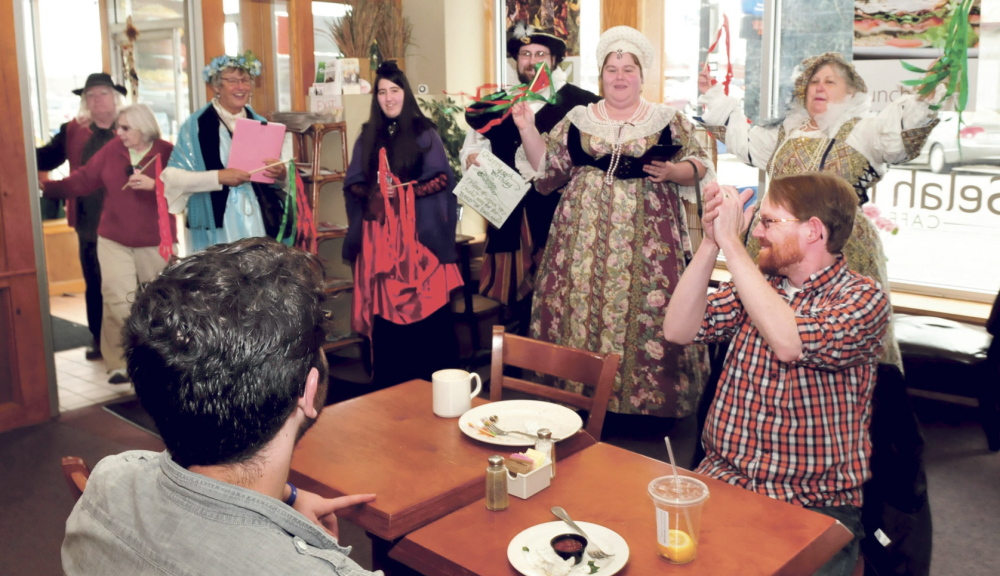 BRAVO: Sean Landry, right, of Pittsfield, claps as members of the Recycled Shakespeare company enter Selah Tea restaurant in Waterville during a celebration of Shakespeare’s 450th birthday on Wednesday. Landry later read one of the Bard’s sonnets.