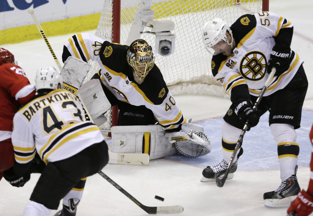 TOUGH D: Boston Bruins defenseman Johnny Boychuk (55) helps keep the puck away from Boston Bruins goalie Tuukka Rask during the third period Wednesday against the Detroit Red Wings. The Red Wings are off to their worst start offensively in the playoffs since 1945.