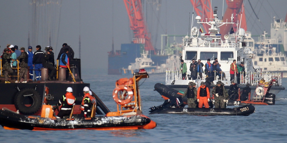 Searchers and divers look for people believed to have been trapped in the sunken ferry Sewol Wednesday. The victims of the April 16 disaster are overwhelmingly students of a single high school in Ansan, near Seoul. More than three-quarters of the 323 students are dead or missing, while nearly two-thirds of the other 153 people on board survived.