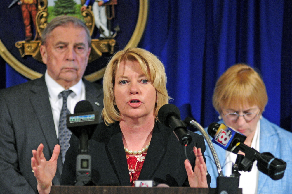 Domestic Violence homicide: Assistant Attorney General Lisa Marchese, center, speaks during a press conference announcing release of the 10th Report of the Domestic Abuse Homicide Review Panel on Thursday in the State House Hall of Flags in Augusta. She is flanked by Department of Public Safety Commissioner John Morris, left, and Attorney General Janet Mills who also spoke at the event.