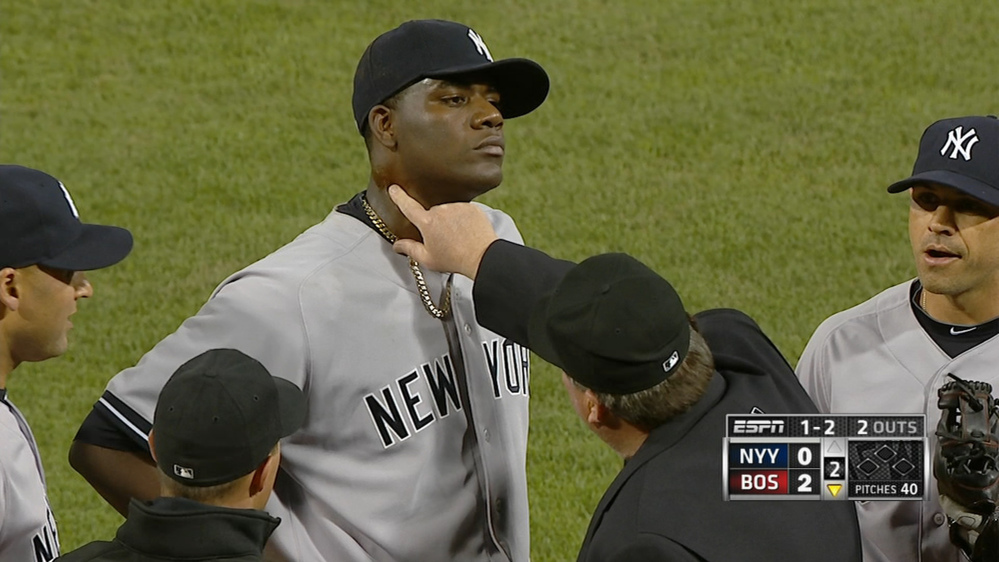 In photo taken from video and provided by ESPN, home plate umpire Gerry Davis touches the neck of New York Yankees starting pitcher Michael Pineda in the second inning of the Yankees-Red Sox game at Fenway Park Wednesday.
