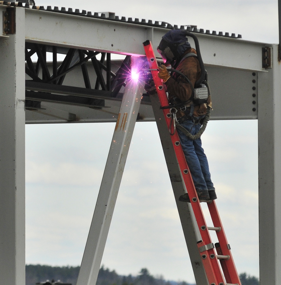 NEW DEVELOPMENT: A welder works on a new building Thursday at the Marketplace at Augusta that will be home to Chipotle Mexican Grill, Yankee Candle, Supercuts, Orange Leaf Frozen Yogurt, Elevation Burger and two other small retailers later this fall.