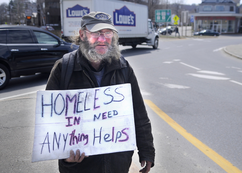 PANHANDLING: Lloyd Bowden, 55, panhandles Friday at Memorial Circle in Augusta. Bowden said he is living in the basement of a relative’s house in Augusta until he can buy a tent. He said the money people give him goes “all to food.”
