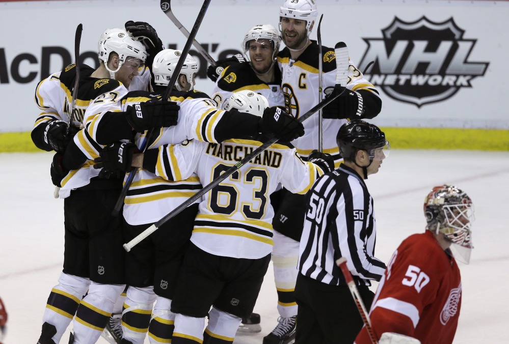 WIN AWAY: Detroit Red Wings goalie Jonas Gustavsson (50) skates by as the Boston Bruins celebrate their 3-2 overtime win in Game 4 against the Detroit Red Wings on Thursday in Detroit. The Bruins have a 3-1 series lead.
