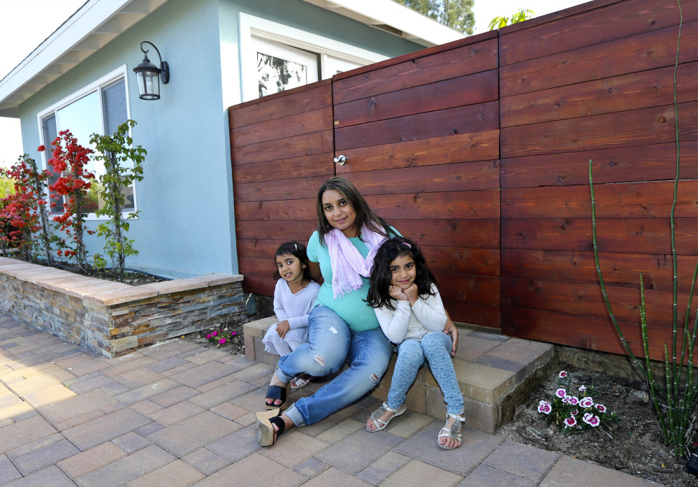 Aniqa Jaswal poses with her daughters, Arissa, right, and Jayda on the front stoop of their home in La Jolla, Calif. After years of renting, Jaswal and her husband needed a “jumbo” mortgage to buy the four-bedroom house. Jumbos are a necessity for nearly everyone in communities such as La Jolla.