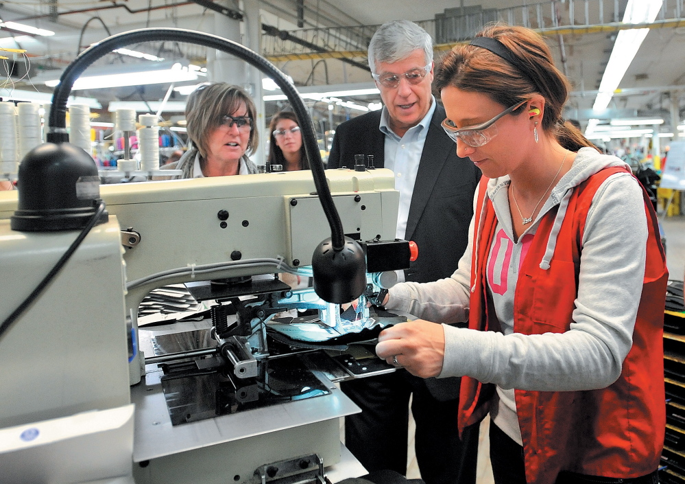 SHOE TOUR: U.S. Rep. Mike Michaud, center, speaks with New Balance factory employee while touring the shoe factory in Norridgewock in March 2012. Michaud toured the plant and picked up a pair of size 12D New Balance running shoes made at the plant for President Barack Obama.