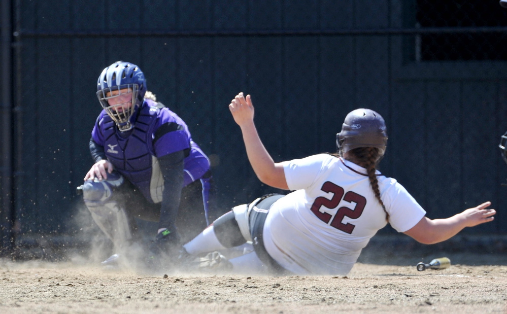 Staff photo by Michael G. Seamans Maine Central Institute's Paige Topel, 22, slides safely in to home plate as Waterville Senior High School catcher Kaitlyn Spaulding, 14, is late with the tag in Waterville.