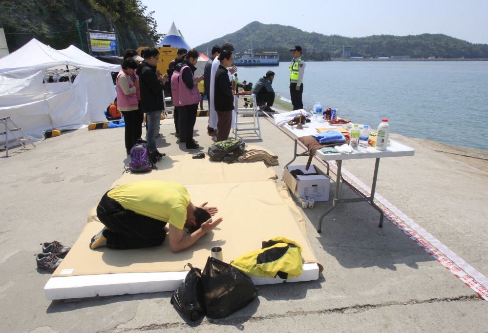 A relative of a passenger aboard the sunken ferry Sewol prays as he waits for news on his missing loved one at a port in Jindo, South Korea, Friday.