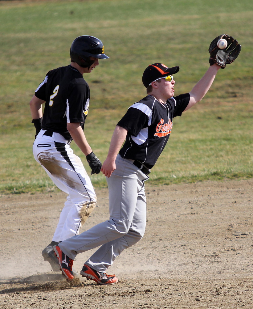 Safe: Gardiner Area High School’s Josh Farrin tries to control a short hop from catcher Ian Moore as Marancook Community School’s Nick LaCasse steals second base during first inning action in Gardiner on Friday. Maranacook won 11-10.