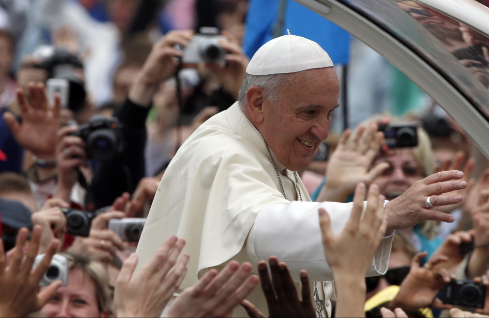 Pope Francis is driven through the crowd after presiding over a solemn ceremony in St. Peter’s Square at the Vatican on Sunday. Francis proclaimed his two predecessors, John XXIII and John Paul II, saints.