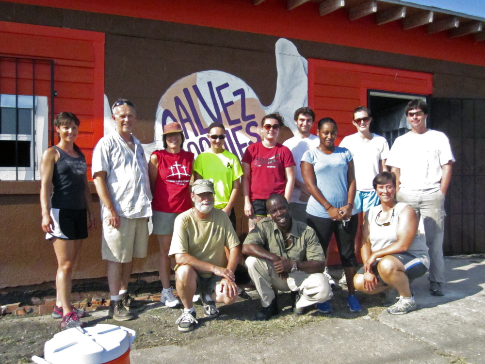 Last year: The Rev. Gary York, pastor of Oakland United Baptist Church, standing second from left; Ted Chaffee, pastor of Gardiner First Baptist Church, kneeling at left; Burnell Cotlon, kneeling at center; Kesha Cotlon, standing third from left; and Emily Webber, kneeling at right, pose with the 2013 mission trip group to New Orleans’ Lower 9th Ward in front of the Cotlons’ store, Galvez Goodies, which they helped repair.