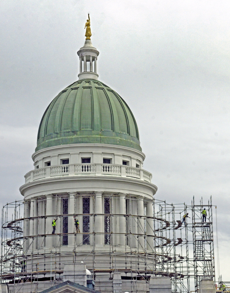 Out with the old: Workers build scaffolding around the State House dome on Wednesday in Augusta. This is the first part of a project to replace the old copper dome on the Capitol.