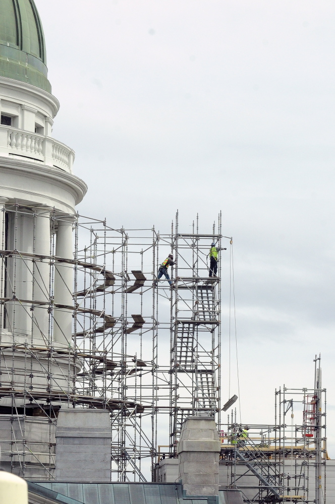 In with the New: Workers build scaffolding around the State House dome on Wednesday in Augusta. This is the first part of a project to replace the old copper dome on the Capitol.