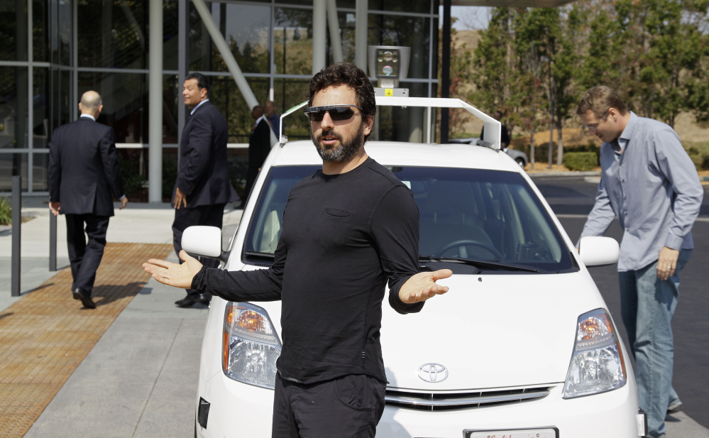 FILE - In this Sept. 25, 2012, file photo, Google co-founder Sergey Brin gestures after riding in a driverless car with officials, to a bill signing for driverless cars at Google headquarters in Mountain View, Calif. Google engineers say they have turned a corner in their pursuit of creating a car that can drive itself. Test cars have been able to navigate freeways comfortably for a few years. On Monday, April 28, 2014, Google said the cars can now negotiate thousands of urban situations that would have stumped them a year or two ago.