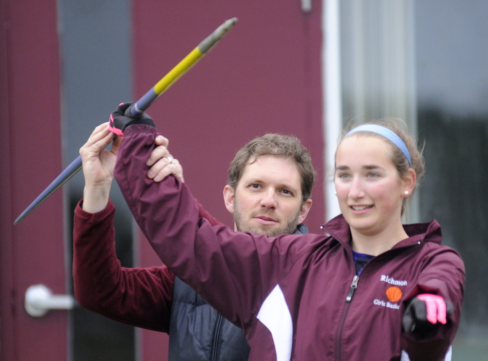 Staff photo by Andy Molloy Richmond Track and Field coach Dave Gagne shows Julie Plummer how to grip a javelin Monday outside the school.